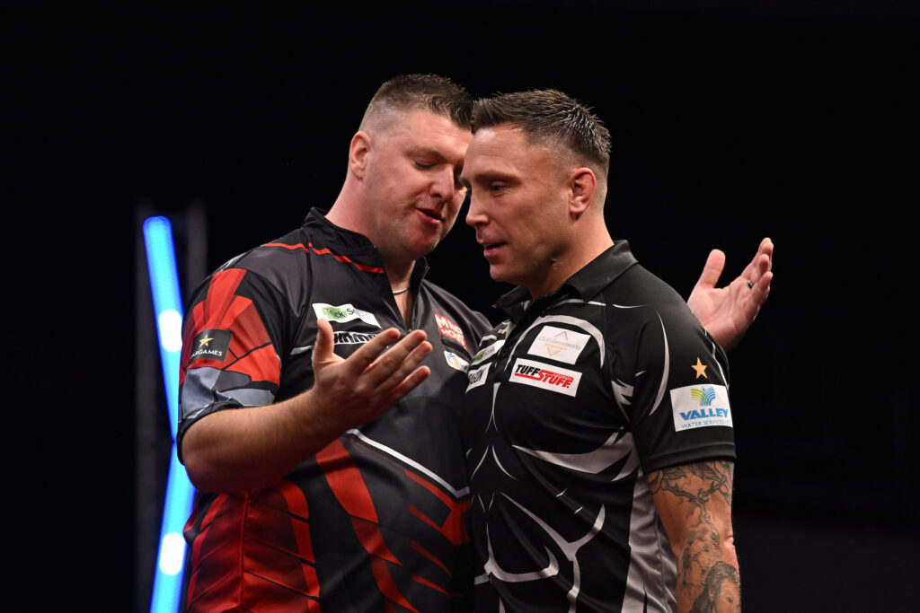 Abklatschen zwischen Daryl Gurney und Gerwyn Price. Gurney hebt beschwichtigend die Hände, Price geht bereits vorbei.