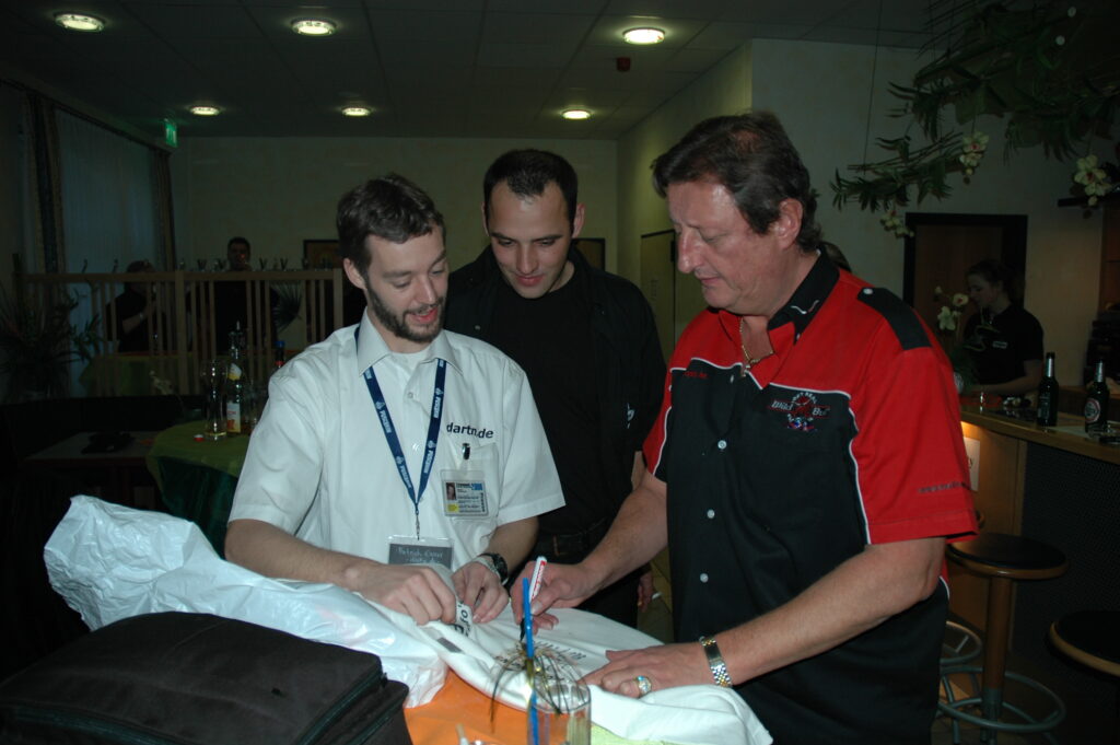 Patrick "Echse" Exner l&auml;sst sich ein Trikot von Eric Bristow unterschreiben